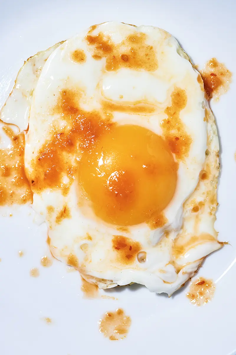 Sunny side up egg with hot sauce
