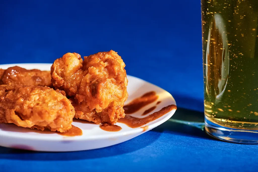 Chicken wings tossed with hot sauce with a beer